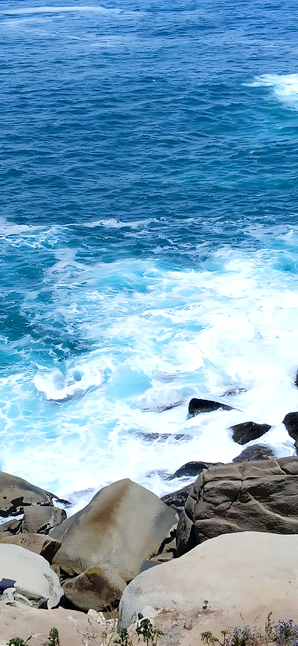 Waves breaking over granite boulders
